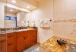 Fresh, clean Gold master bath with custom cabinetry, new tile and granite counter